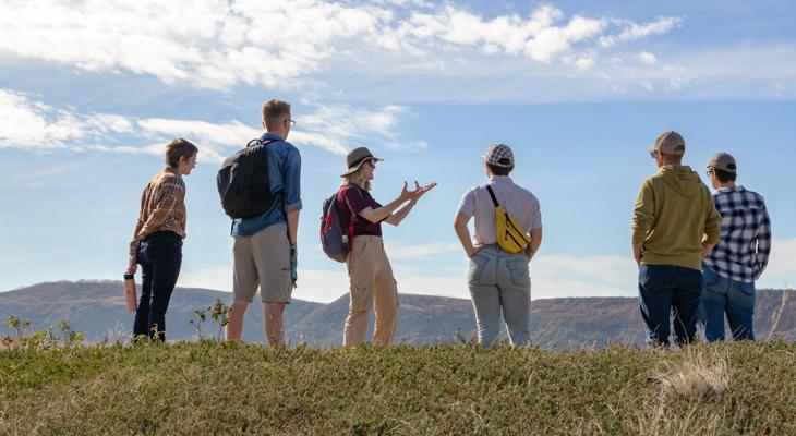 An educator speaks to a small group of people outdoors.